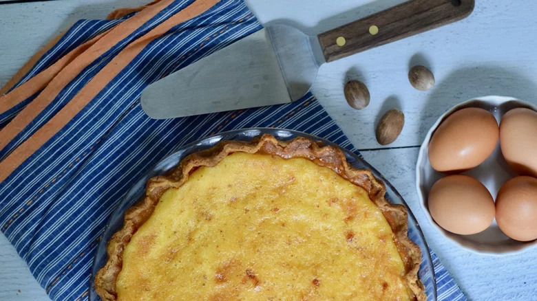 custard pie with eggs and serving utensil