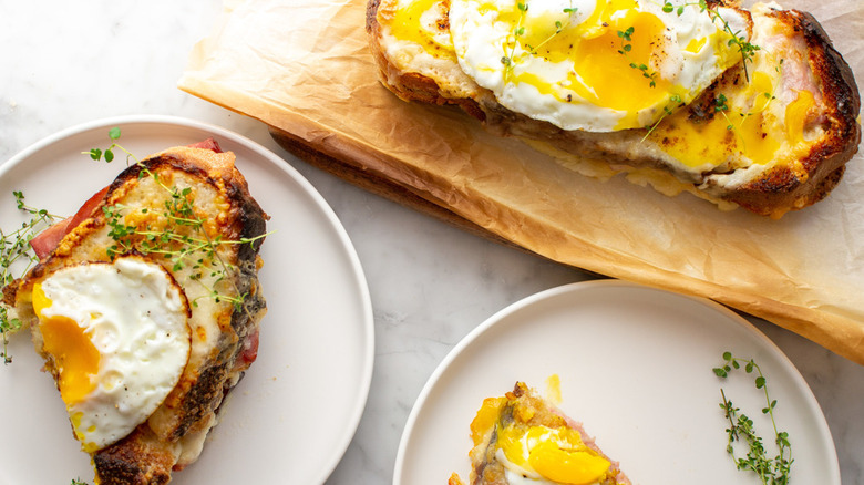 plates and board with croque madame sandwich