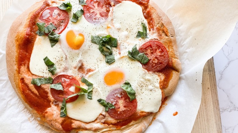 egg pizza on wooden cutting board