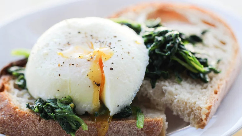 close up of toast with poached egg and spinach