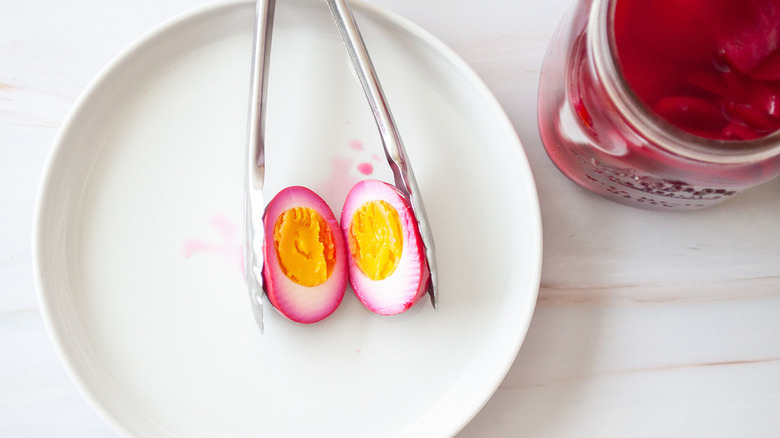 plate with pickled egg and tongs and jar