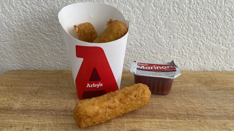 Arby's mozzarella sticks beside marinara dipping cup