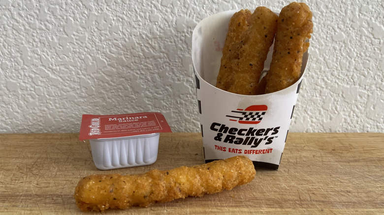 Rally's Mozzarella Stix beside marinara sauce cup