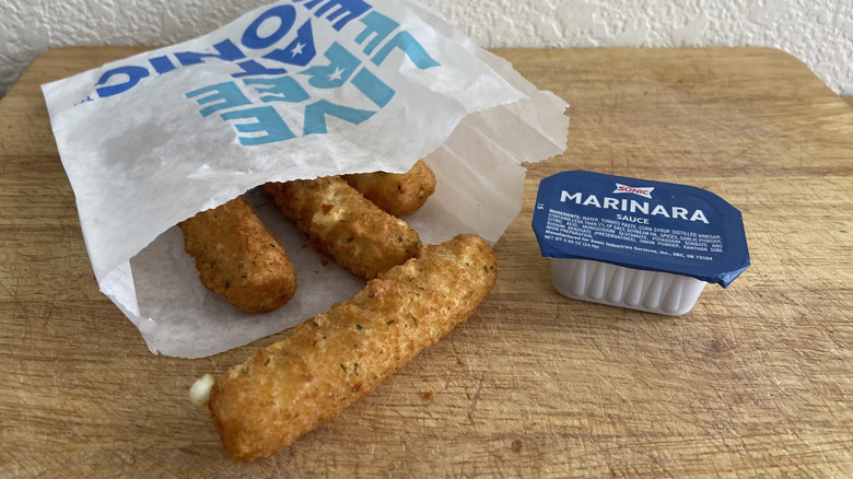 small bag of Sonic mozzarella sticks beside marinara dipping cup