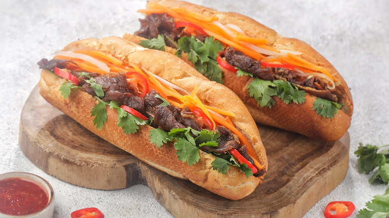 Two bahn mi sandwiches on wood board
