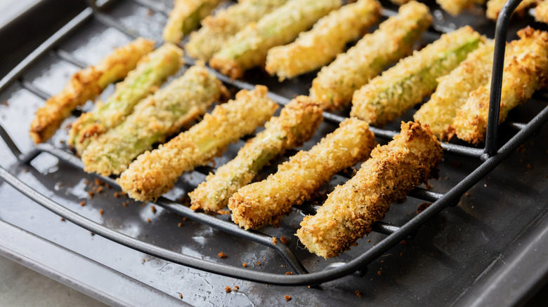 Fried zucchini on an oven rack with some crispy and some not