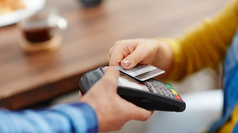 Hands paying with credit card on point of sale machine