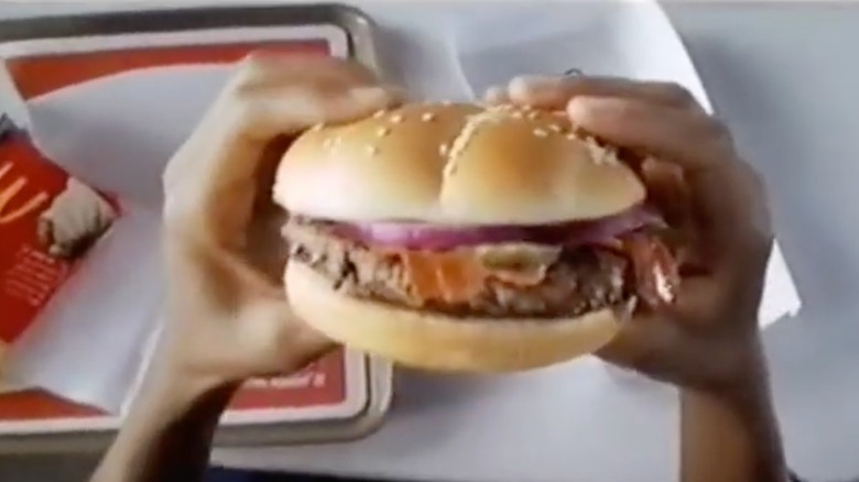 Hands holding an Angus Third Pounder burger from McDonald's