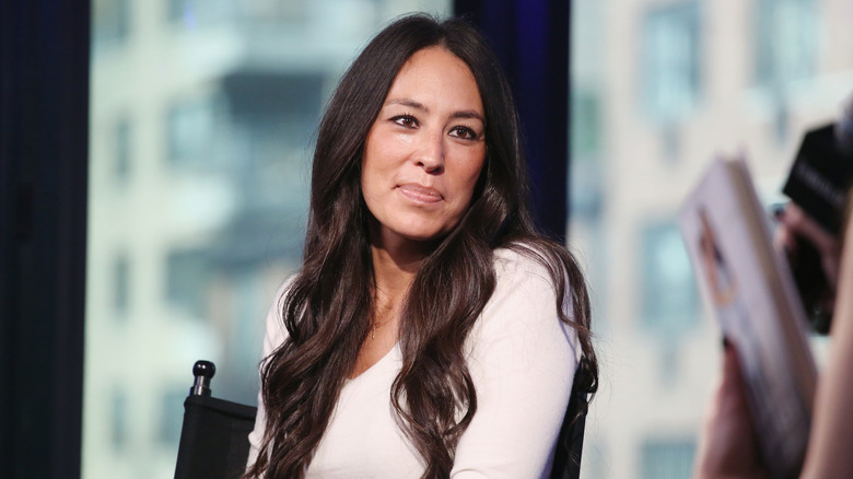 Joanna Gaines of Magnolia seated at an event, looking off to the side