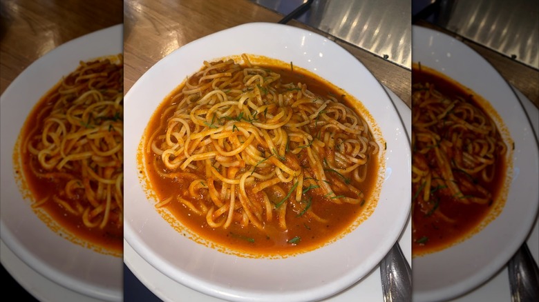 bowl of linguine with crab-filled tomato sauce in a white bowl