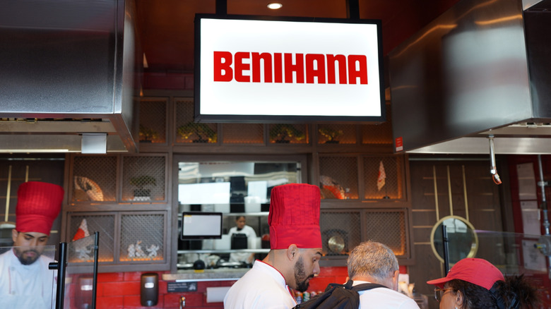 Chefs at Benihana wearing red chef hats in the kitchen