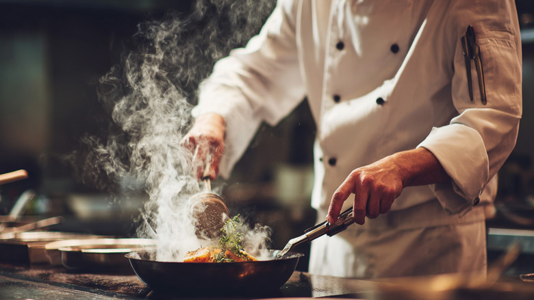 Chef cooking with a pan in the kitchen