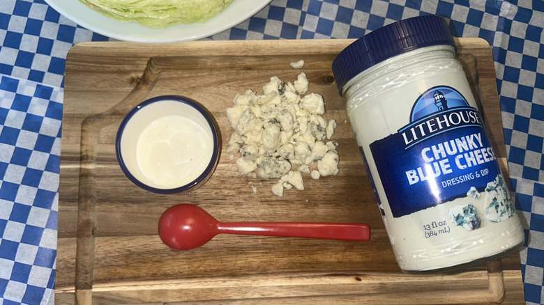 Jar of Litehouse blue cheese dressing with crumbled blue cheese and red spoon