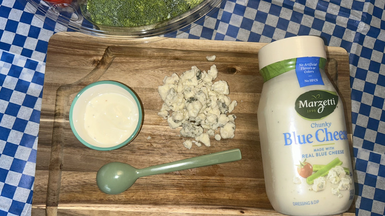 Jar of Marzetti blue cheese, ramekin, green spoon and crumbled blue cheese