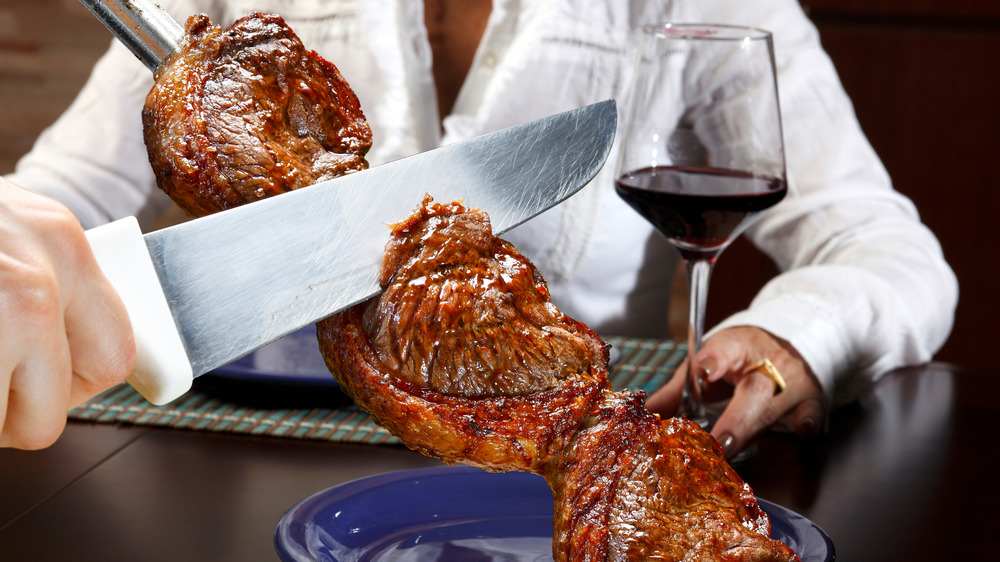 A knife carving meat at a Brazilian Steakhouse