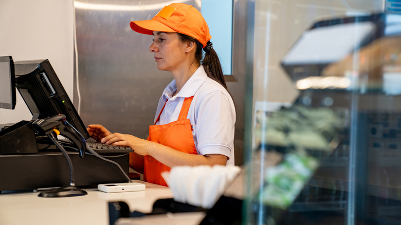 Employee working a cash register not smiling