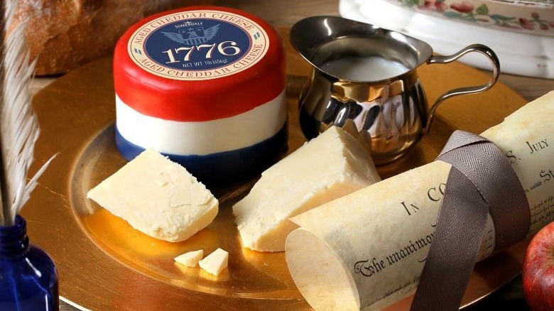 1776 aged cheddar cheese in red, white, and blue wax next to Declaration of Independence copy