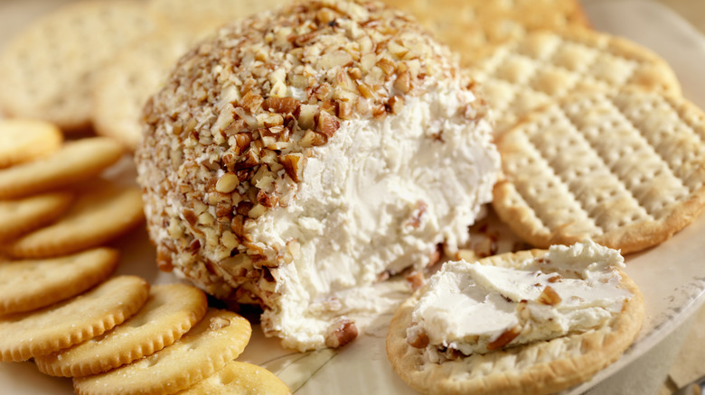 Sliced cheese ball on a plate with crackers