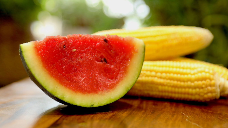 Close-up of a slice of watermelon and corn on the cob