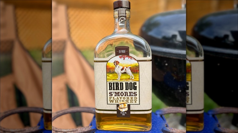 Bottle of Bird Dog S'mores outside near a grill