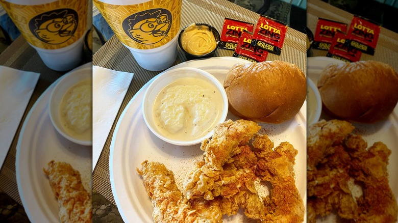 plate of fried chicken tenders, a roll, and sauce from Golden Chick