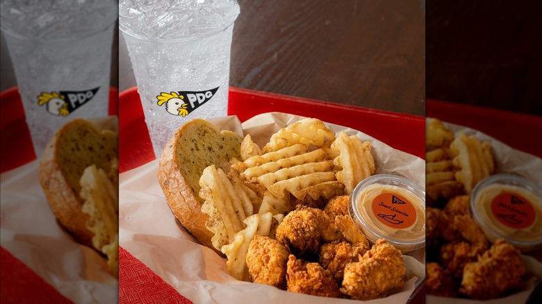 Basket of chicken nuggets, fries, and Texas toast with a soda on a red tray