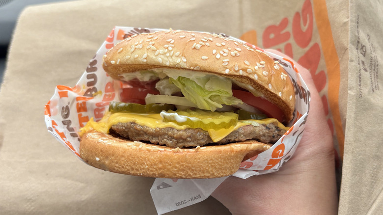 Burger King Whopper with cheese in hand with wrapper
