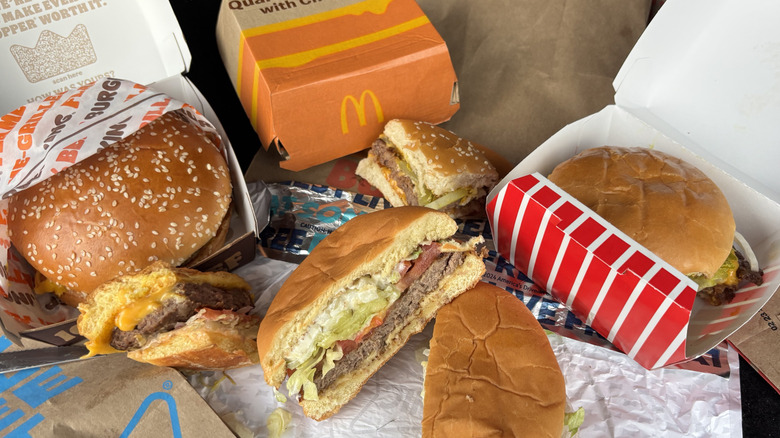 Variety of fast food cheeseburgers and some cut into wedges