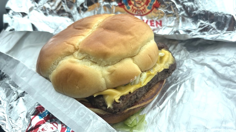 Wendy's cheeseburger on potato bun in fast food wrapper