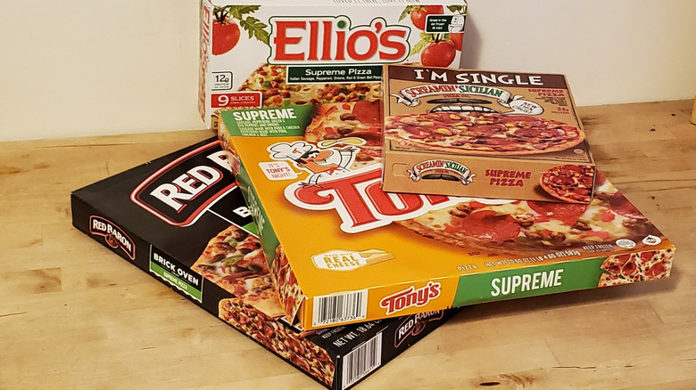 A stack of pizza boxes from different frozen brands