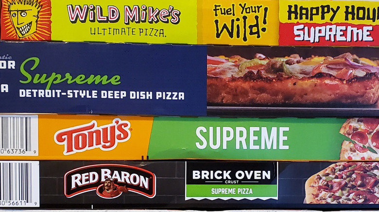 A stack of pizza boxes from different frozen brands
