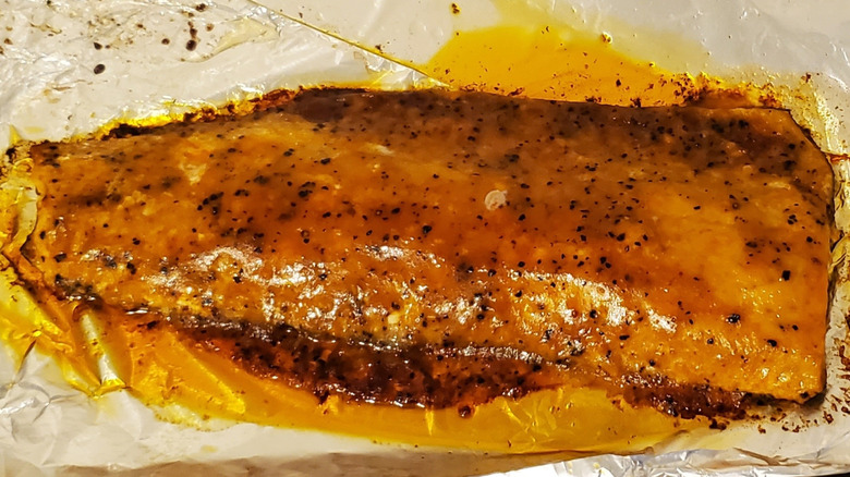 A large peppercorn seasoned salmon fillet on foil