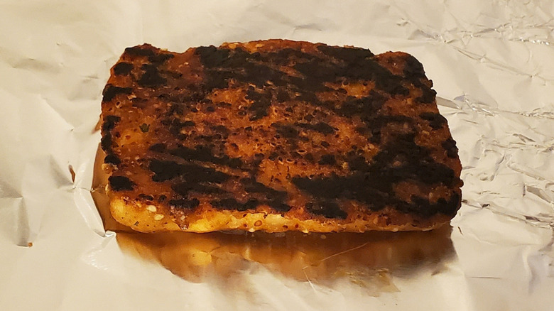 An overcooked salmon fillet on foil