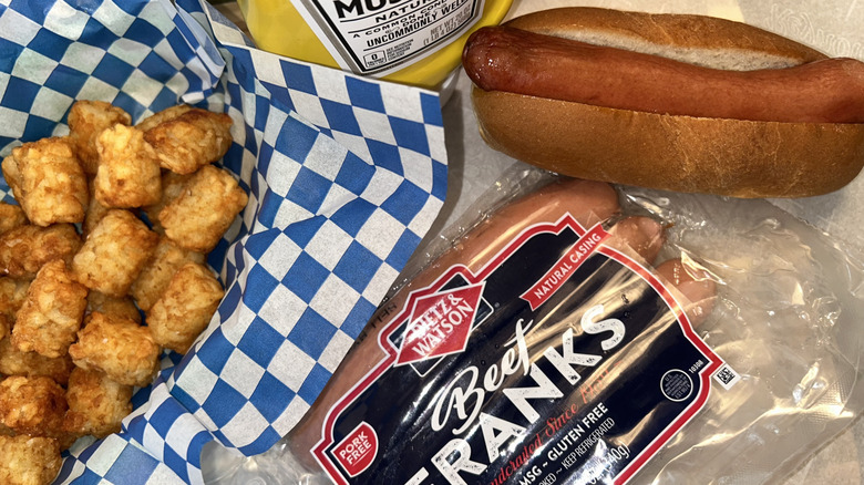 Dietz & Watson hot dog package and hot dog on bun with tater tots
