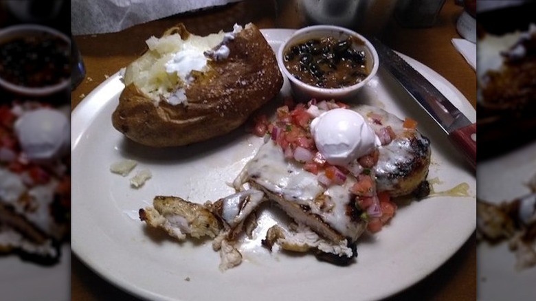 Southwest chicken and baked potato on a white plate