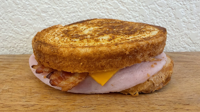 Supreme Sourdough Breakfast Sandwich with ham, bacon, egg, and cheese