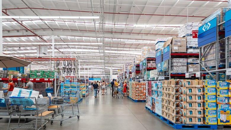 Several shoppers with carts inside a Sam's Club store.