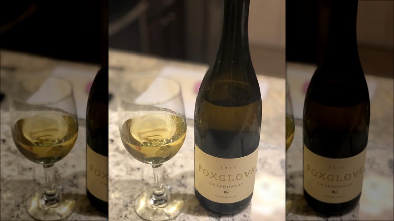 A glass of white wine with a bottle of Foxglove Chardonnay