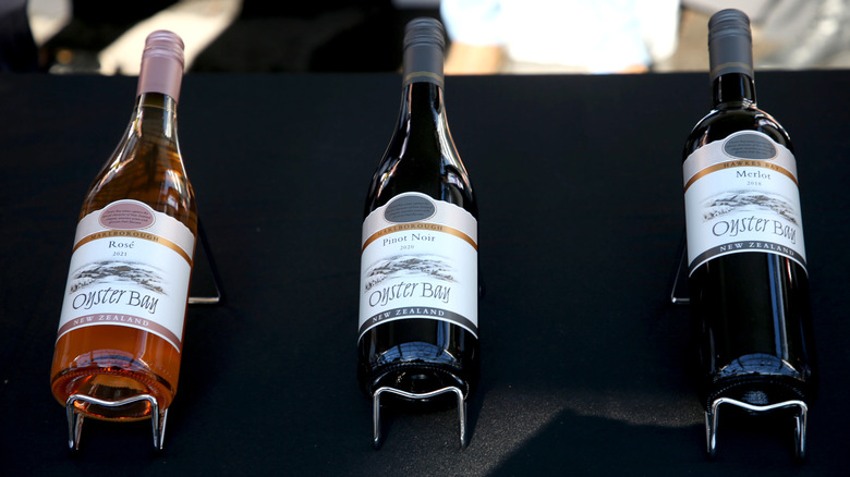 Bottles of Oyster Bay rosé, pinot noir, and merlot mounted on a black display board