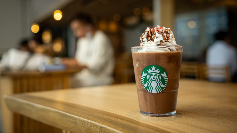 Starbucks peppermint mocha frappuccino in glass on table at coffee shop