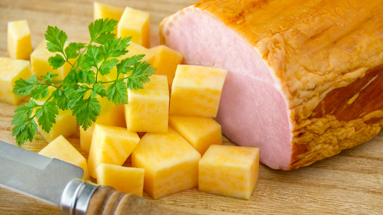 Cooked cubes of rutabaga garnished with herbs next to pork