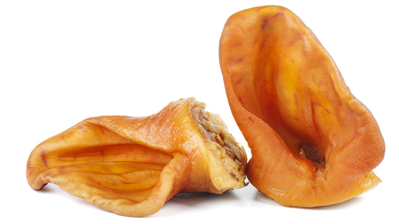 Two pig ears isolated against a white background