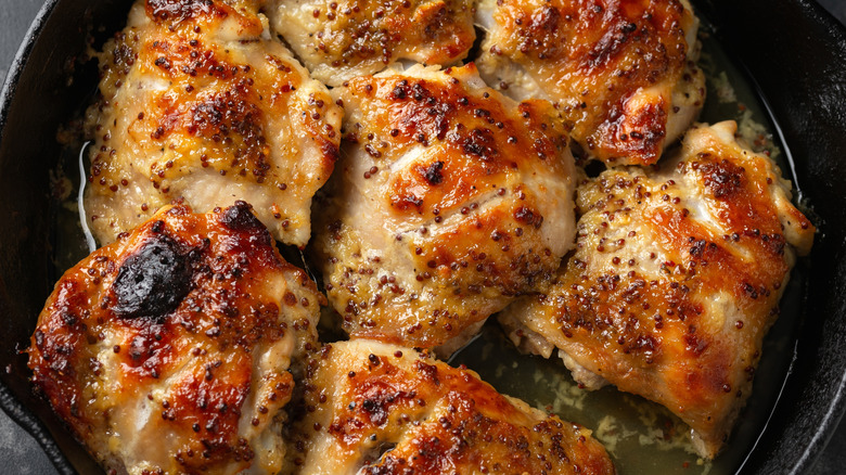 Close up of honey mustard chicken thighs in cast iron pan