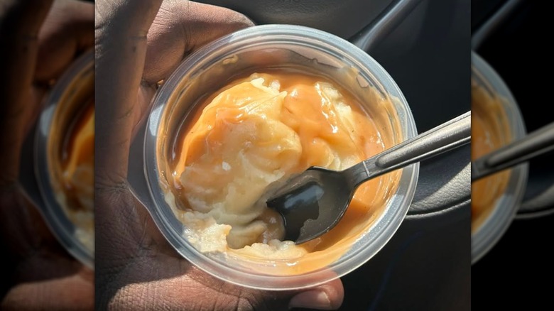 Plastic to-go container of KFC mashed potatoes and gravy from a store in the U.K.