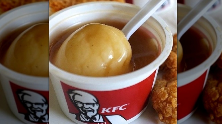 To-go cup of mashed potatoes and gravy with a plastic spoon in it