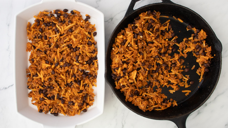 black beans, shredded potatoes, and ground meat in a white baking pan