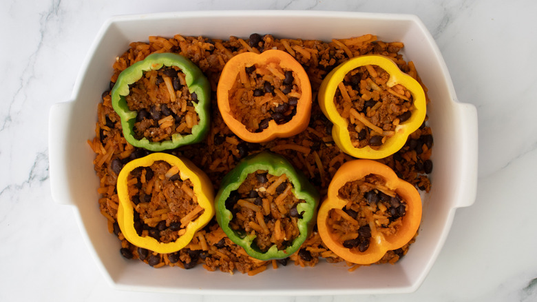 stuffed bell peppers in a white baking pan