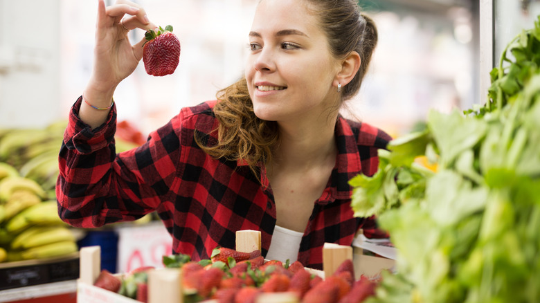 Woman holding up strawberry