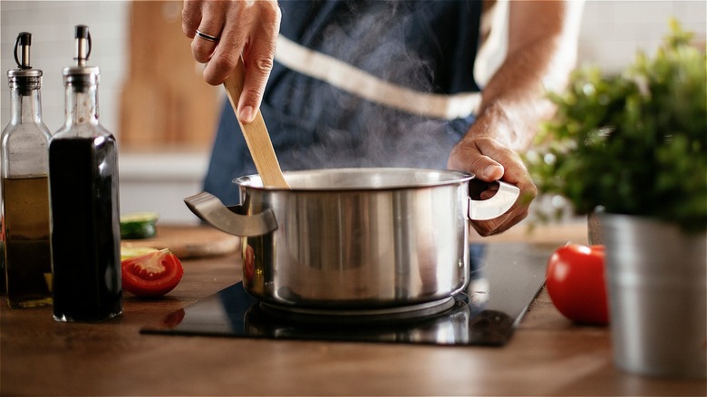 Man stirring steaming pot