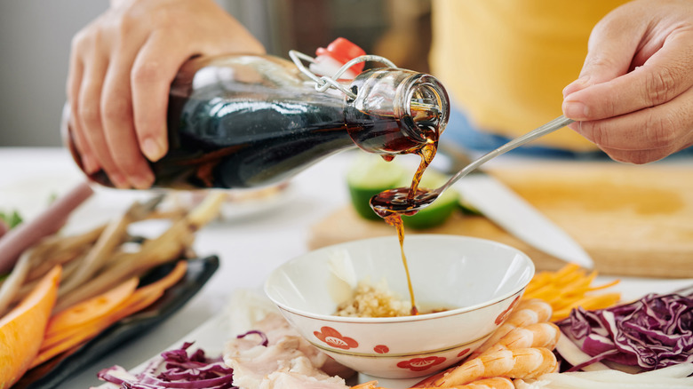 Person using a bottle of soy sauce